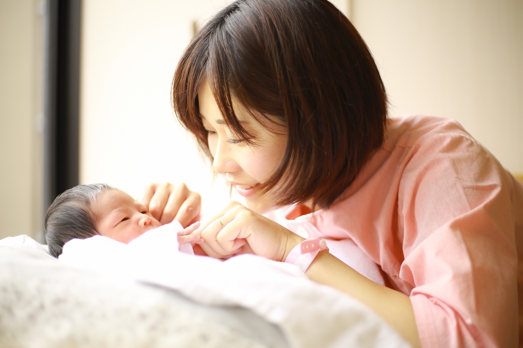 新生児を見つめるお母さん